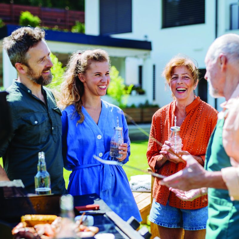 Multi generation family grilling outside on backyard in summer during garden party; Shutterstock ID 2556256389; purchase_order: Customer contribution; job: 4706510; client: Sonova Australia ; other: Sonova
